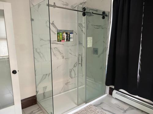a shower with a glass door in a bathroom at HomeStay B&B in Boston - 3 locations in Dorchester in Boston