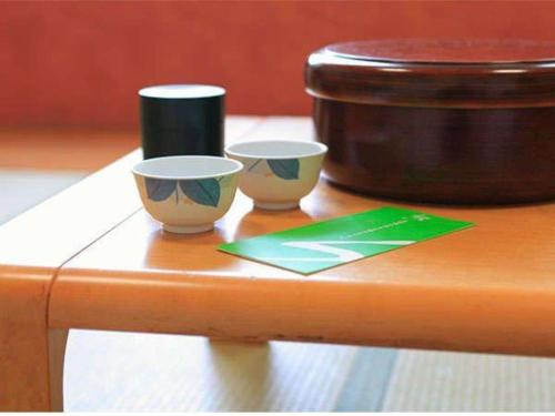 two cups sitting on top of a wooden table at Hotel SP Haruno in Kochi