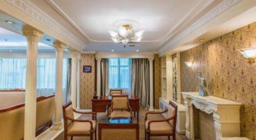 a living room with a table and chairs and a fireplace at Jincheng Pacific Hotel in Jincheng