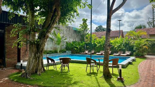 a yard with chairs and a table and a pool at Song Ngư Riverside Homestay in Can Tho