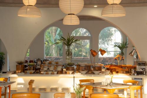 a restaurant with tables and chairs and windows at The Up Hotel Phu Quoc Island - The Poolside Escape in Phu Quoc