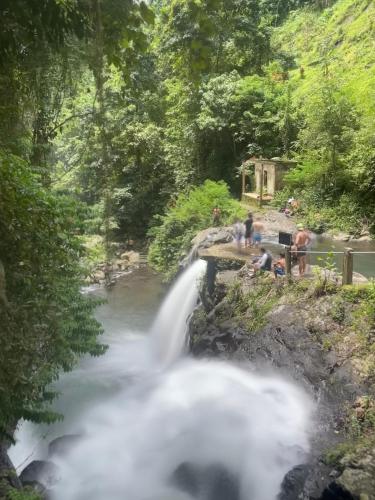 a waterfall in the middle of a river at Tranquil Riverside Camping in Ambengan
