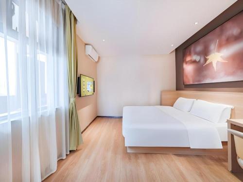 a bedroom with a white bed and a large window at IU Hotel Kunming Jinma Bijifang Joy City in Kunming