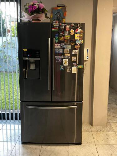 a large black refrigerator with many magnets on it at Nyumbani place that means home in Sydney