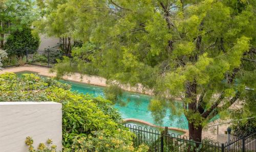 a swimming pool with a tree next to a fence at Beach-Pool-Tennis-Ocean Views-All at Your Door in Surf Beach
