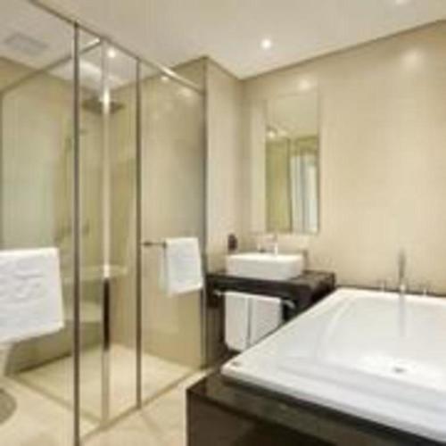 a bathroom with a shower and a tub and a sink at Hotel Haus in Gapyeong