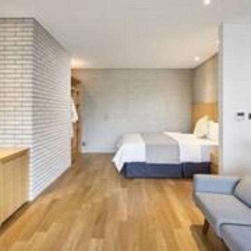 a bedroom with a bed and a couch in it at Hotel Haus in Gapyeong