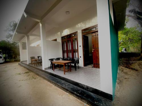 a porch of a house with a table and chairs at River Nature Park in Polonnaruwa
