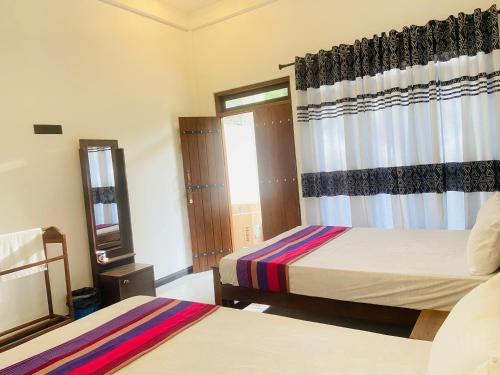 a hotel room with two beds and a window at River Nature Park in Polonnaruwa