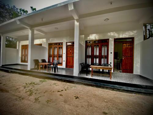a house with red doors and a table and chairs at River Nature Park in Polonnaruwa