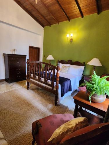 a bedroom with a bed and a green wall at The Villa at Galapitiyaya Estate in Haputale