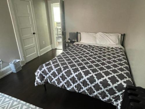 a bedroom with a bed with a black and white comforter at HomeStay in Boston - Dorchester Fields Corner Area in Boston