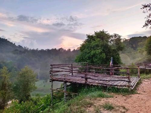 a bench on a hill with a view of a river at Homestay LubokSawah in Pekan Nanas