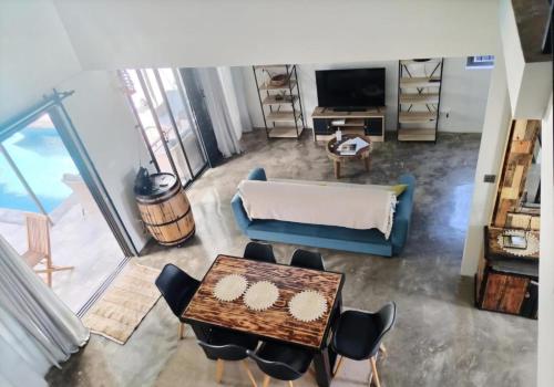 a living room with a couch and a table and chairs at Villa Pierre Precieuse Private pool and garden in Cap Malheureux