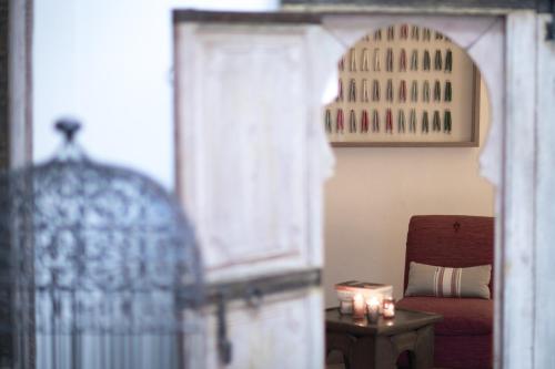 a bedroom with a bed and a chair and a table at Riad Altair in Marrakech