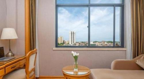 a living room with a vase of flowers on a table at Vienna Hotel Guangxi Fangcheng in Fangcheng