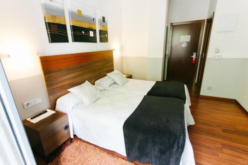 a bedroom with a large bed with a wooden headboard at Hostal San Ignacio Centro in San Sebastián