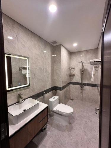a bathroom with a toilet and a sink and a mirror at Wind Homestay & Apartment in Danang