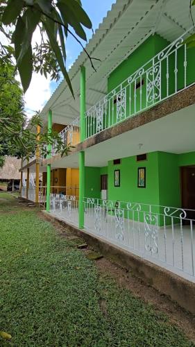 a green and white building with a balcony at Finca El Encanto in Melgar
