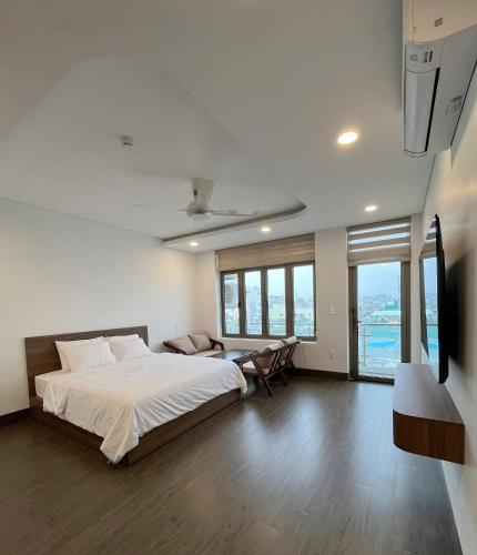 a bedroom with a bed and a tv and some windows at Wind Homestay & Apartment in Danang