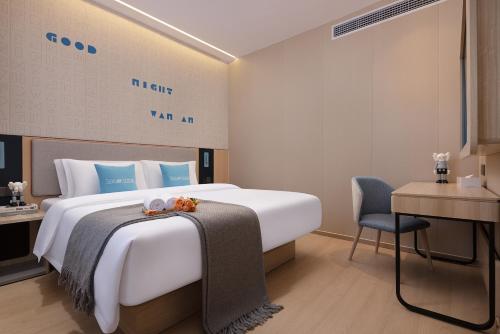 a hotel room with a large bed and a chair at Zhangjiajie Homeinn Boutique Hotel in Zhangjiajie