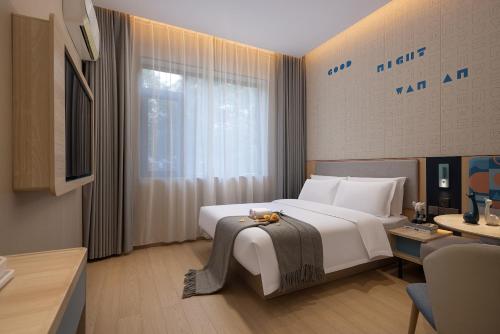 a bedroom with a large white bed and a window at Zhangjiajie Homeinn Boutique Hotel in Zhangjiajie