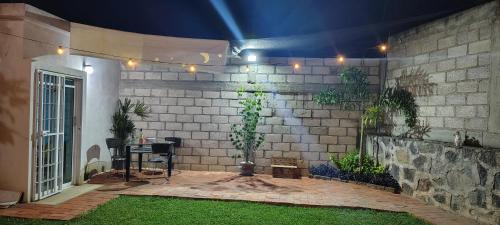a patio with a brick wall with a table and plants at Casa Palmer, con gran jardín in Totolapan