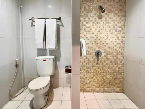 a small bathroom with a toilet and a shower at Garuda Hotel Pontianak in Pontianak