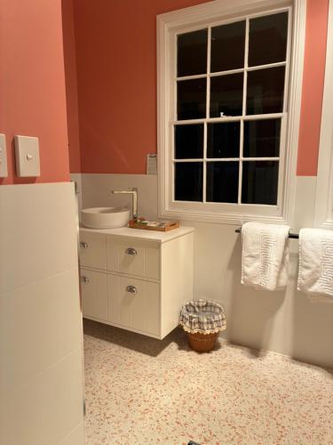 a bathroom with a sink and a window at Capers Cottage and Barn Accommodation in Wollombi