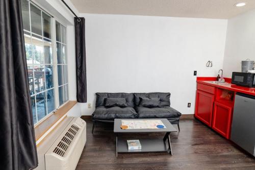 a living room with a couch and a table at Rose City Inn & Suites in Oak Grove
