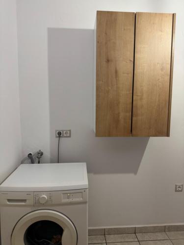 a kitchen with a washing machine and a cabinet at Zen KF Suites in Firókambos