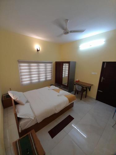 a bedroom with a large bed and a table at Majestic Serviced Villa in Kottayam