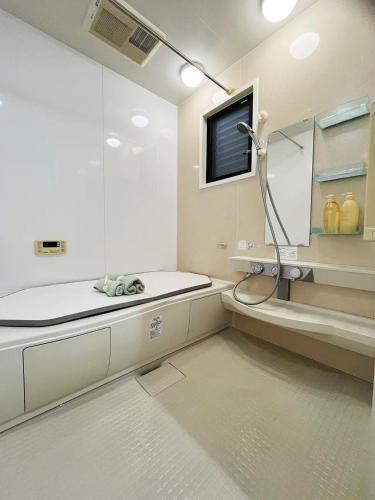a bathroom with a shower and a sink and a tv at 子安居 Koyasui in Yokohama