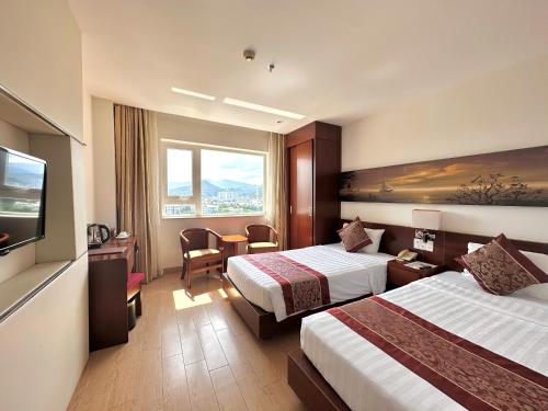 a hotel room with two beds and a television at Nha Trang Wonderland Hotel in Nha Trang