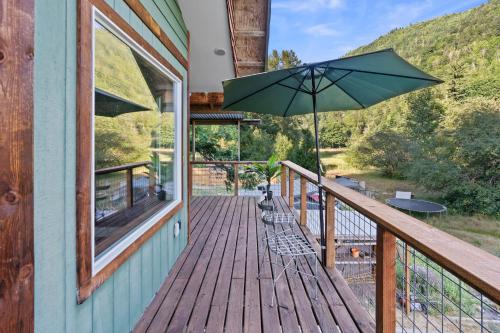 a balcony with an umbrella on a house at The Cascade Cabin in Maple Falls