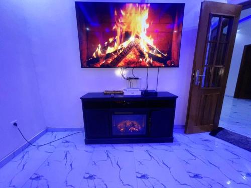 a living room with a fireplace with a tv on the wall at 2chambres salon villa Thierno sene in Niakoul Rap