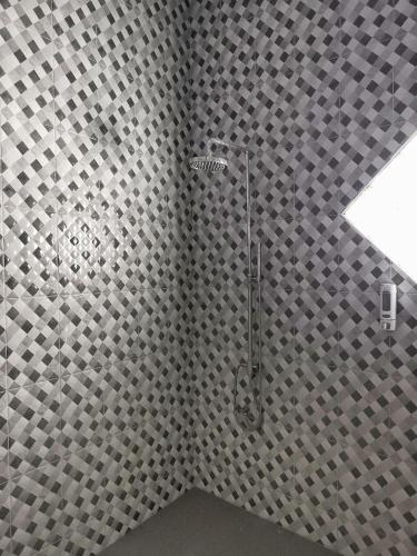 a shower with a checkered shower curtain in a bathroom at Benada Piyungan Yogyakarta by ABM in Yogyakarta