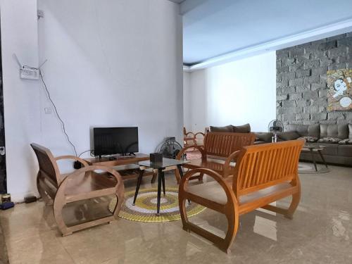 a living room with chairs and a table and a couch at Benada Piyungan Yogyakarta by ABM in Yogyakarta
