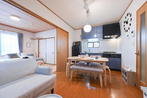 a room with a bed and a table and a kitchen at Modern & Spacious Family House - 15 mins to Haneda Airport in Tokyo