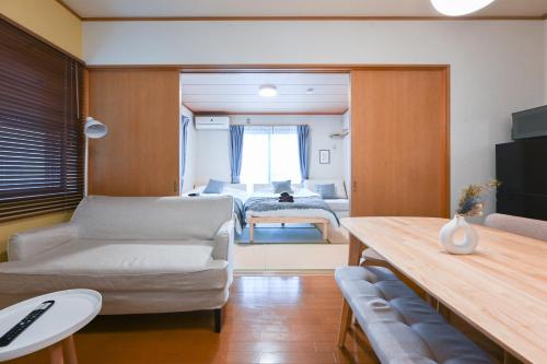 a living room with a couch and a bedroom at Modern & Spacious Family House - 15 mins to Haneda Airport in Tokyo