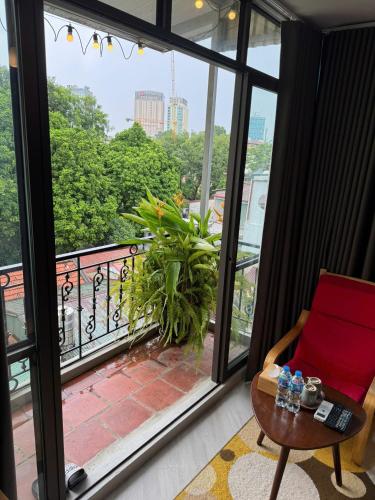 a room with a red chair and a balcony at T Home Balcony Homestay in Hanoi