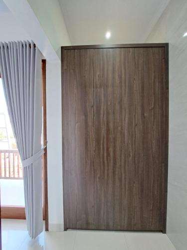 a sliding wooden door in a room with a window at Paddy Villa Sanur in Sanur