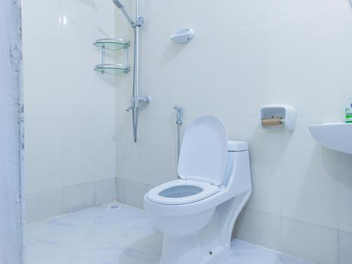 a white bathroom with a toilet and a sink at Spacious Beachfront Condo -AC - WiFi, Uroa Escape Zanzibar in Uroa