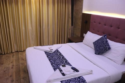 a hotel room with a bed with two napkins on it at Best Hotel in Mumbai