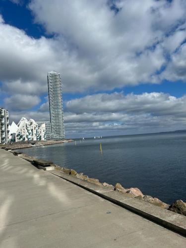 a view of the ocean with a building in the background at New copy apartment at Aarhus Ø in Aarhus