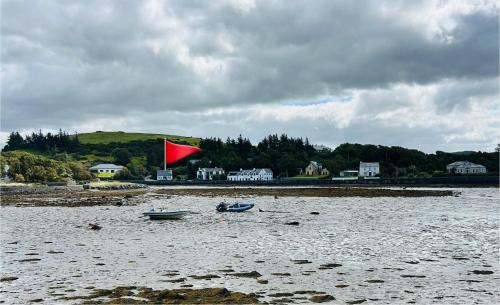 two boats in the water with a red flag at Seafront Cottage Amazing Seaview 3 Double Bedrooms in Westport
