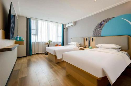 a hotel room with two beds and a large window at City Comfort Inn Nanning Guangxi University in Nanning