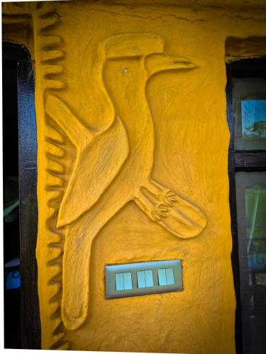 a wooden carving of a bird on the side of a door at Babai Outback Adventures PVT LTD in Bardia