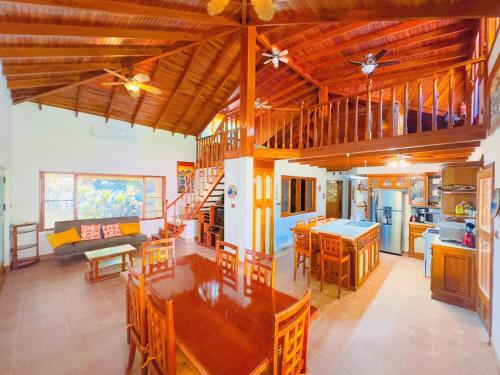 a large kitchen and living room with wooden ceilings at Casa Mariposa cozy house 5 minutes from the beach in Sámara