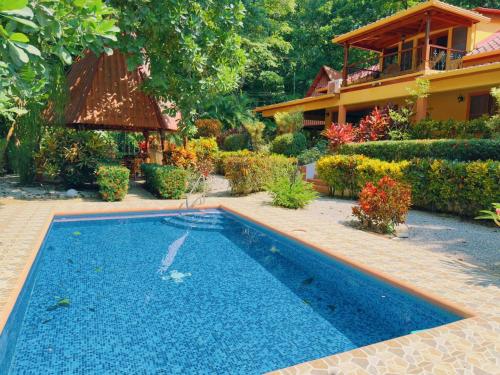 a swimming pool in front of a house at Casa Mariposa cozy house 5 minutes from the beach in Sámara